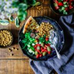 silver spoon on black ceramic bowl with vegetables